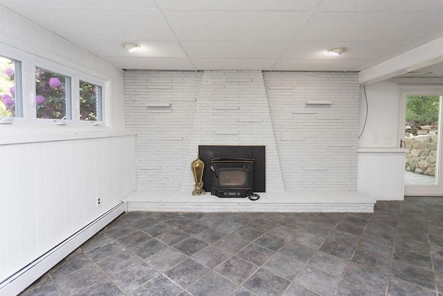 38 Williams Rd, Smithfield, RI 02917 - detailed view of baseboard heating, a wood stove, a paneled ceiling, and brick wall