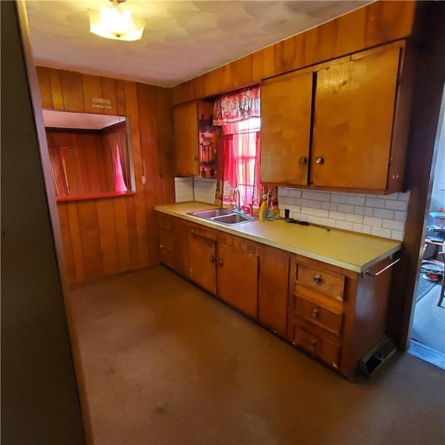 199 Plainfield Pike, Scituate, RI 02857 - kitchen with a sink, brown cabinetry, light countertops, light colored carpet, and wood walls