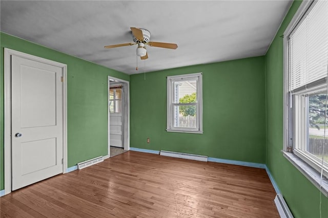 16 King Rd, Middletown, RI 02842 - unfurnished bedroom with baseboard heating, multiple windows, and wood finished floors