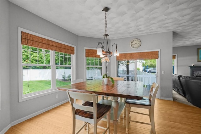510 Westmoreland Ln, North Kingstown, RI 02874 - dining room featuring a chandelier, healthy amount of natural light, baseboards, and light wood-style floors