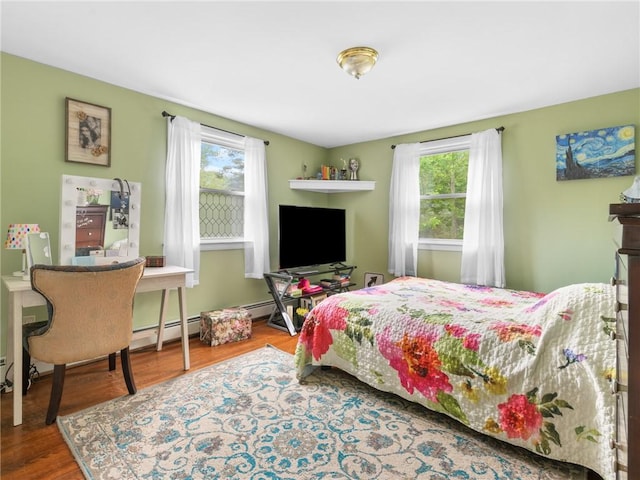 860 Centerville Rd, Warwick, RI 02886 - bedroom featuring multiple windows, wood finished floors, and a baseboard heating unit