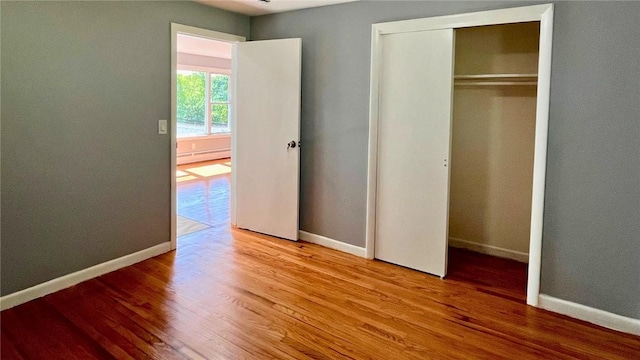 106 Leigh Rd, Cumberland, RI 02864 - unfurnished bedroom with wood finished floors, baseboards, baseboard heating, and a closet
