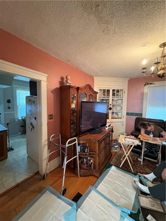 202 Jenckes St, Woonsocket, RI 02895 - living room featuring a textured ceiling, wood finished floors, and a chandelier