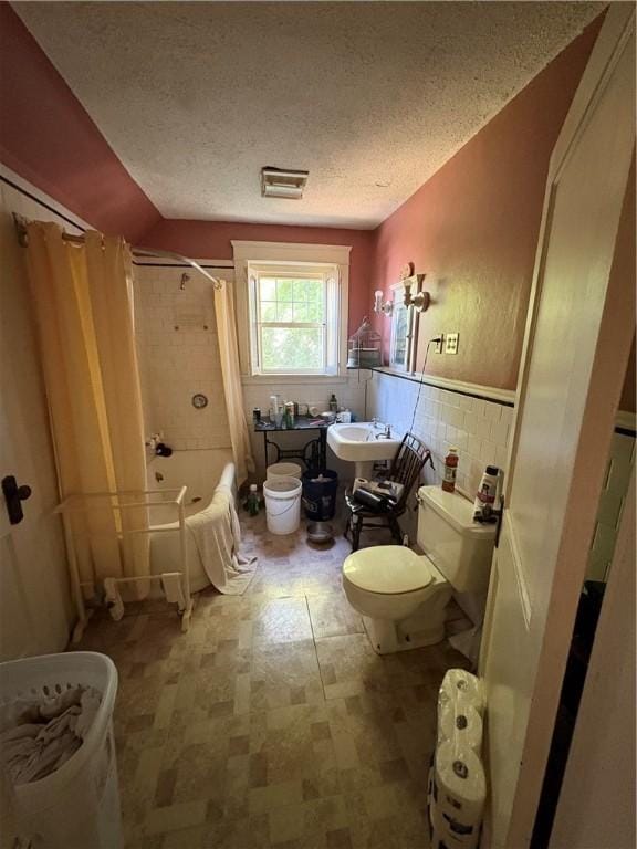 202 Jenckes St, Woonsocket, RI 02895 - bathroom featuring toilet, tile walls, tile patterned floors, shower / tub combo with curtain, and a sink
