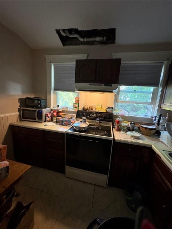 202 Jenckes St, Woonsocket, RI 02895 - kitchen with range with electric cooktop, under cabinet range hood, stainless steel microwave, light countertops, and tile patterned flooring