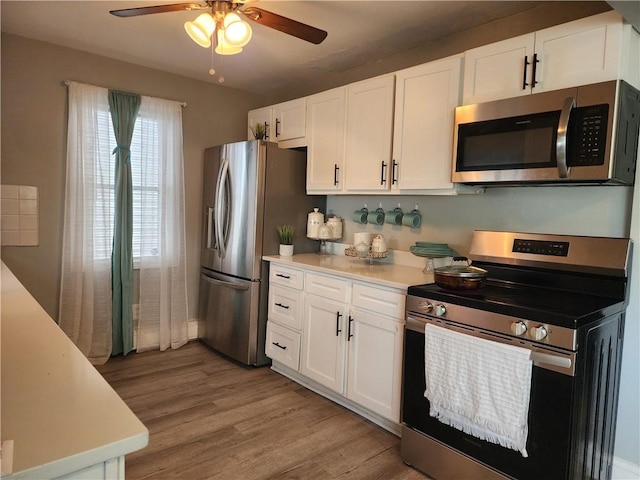 27 Unit St, Providence, RI 02909 - kitchen featuring appliances with stainless steel finishes, light countertops, ceiling fan, light wood finished floors, and white cabinetry