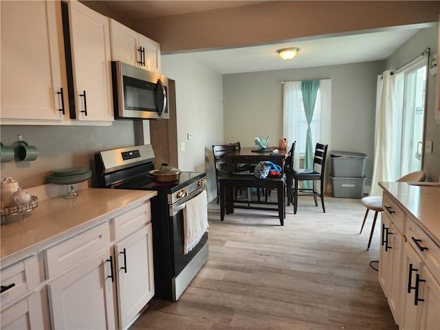 27 Unit St, Providence, RI 02909 - kitchen with appliances with stainless steel finishes, light wood finished floors, white cabinetry, and light countertops