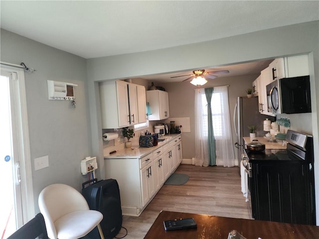 27 Unit St, Providence, RI 02909 - kitchen featuring stainless steel appliances, white cabinetry, light wood-style floors, a ceiling fan, and light countertops