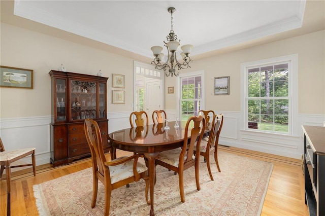 43 Kayla Ricci Way, Exeter, RI 02874 - dining area featuring a chandelier, a raised ceiling, wainscoting, light wood-type flooring, and ornamental molding