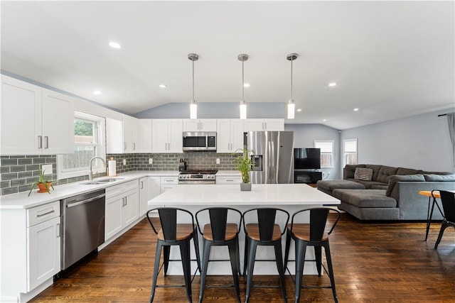 149 Weeden Dr, Warwick, RI 02818 - kitchen featuring appliances with stainless steel finishes, a sink, lofted ceiling, a kitchen bar, and plenty of natural light