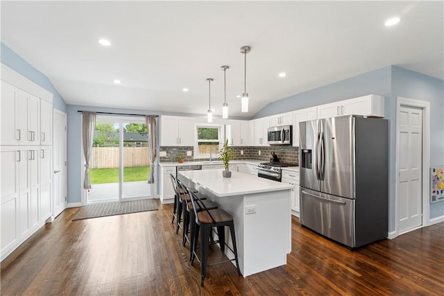 149 Weeden Dr, Warwick, RI 02818 - kitchen with stainless steel appliances, lofted ceiling, a kitchen breakfast bar, a center island, and dark wood-style flooring