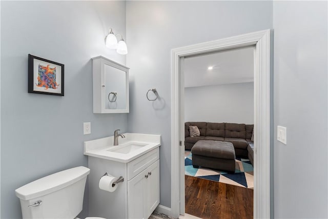 149 Weeden Dr, Warwick, RI 02818 - half bath with vanity, toilet, connected bathroom, and wood finished floors