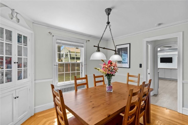 44 Felsmere Ave, Pawtucket, RI 02861 - dining room with crown molding, light wood-style flooring, arched walkways, and baseboards