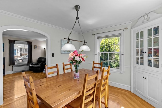 44 Felsmere Ave, Pawtucket, RI 02861 - dining room with radiator heating unit, arched walkways, crown molding, healthy amount of natural light, and baseboards