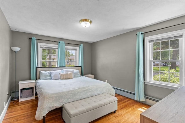 299 Buttonwoods Ave, Warwick, RI 02886 - bedroom featuring multiple windows, light wood finished floors, a baseboard heating unit, and baseboards