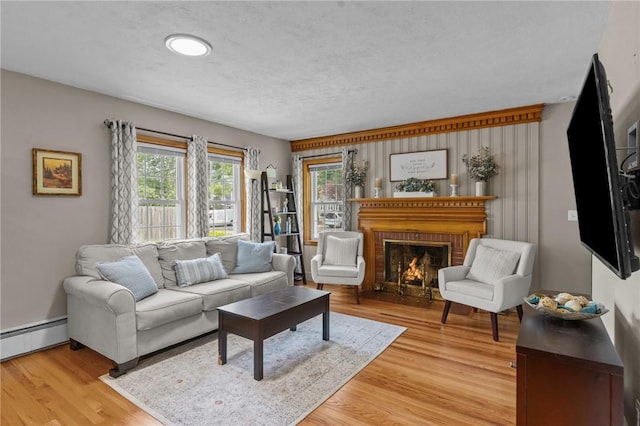 299 Buttonwoods Ave, Warwick, RI 02886 - living area featuring baseboard heating, light wood-type flooring, a brick fireplace, and baseboards