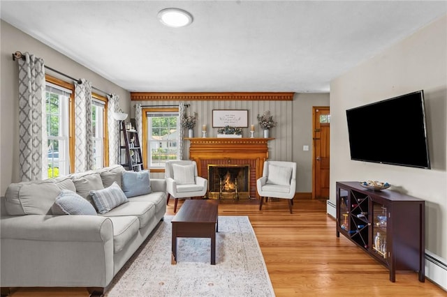 299 Buttonwoods Ave, Warwick, RI 02886 - living area with healthy amount of natural light, a baseboard radiator, and light wood finished floors
