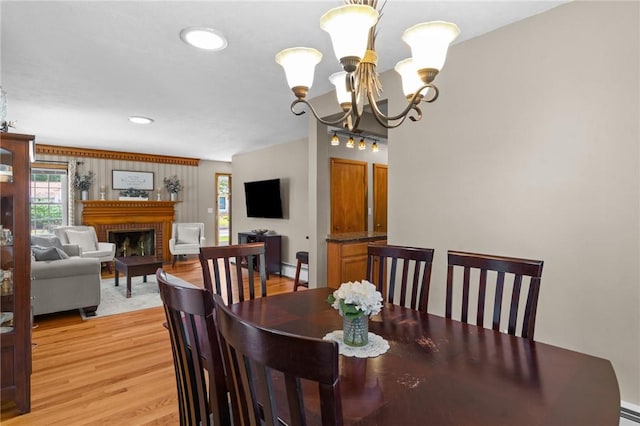 299 Buttonwoods Ave, Warwick, RI 02886 - dining room with a chandelier, light wood-type flooring, a brick fireplace, baseboard heating, and baseboards