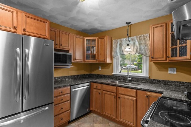 299 Buttonwoods Ave, Warwick, RI 02886 - kitchen with stainless steel appliances, a sink, brown cabinets, glass insert cabinets, and decorative light fixtures