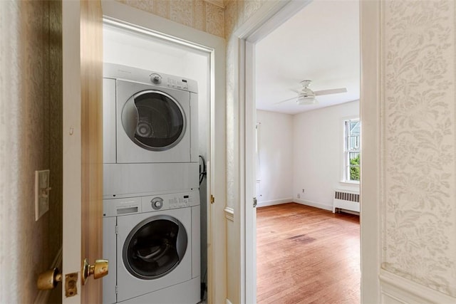 37 Beaumont St, East Providence, RI 02916 - laundry room featuring radiator, stacked washer / drying machine, wallpapered walls, wood finished floors, and ceiling fan