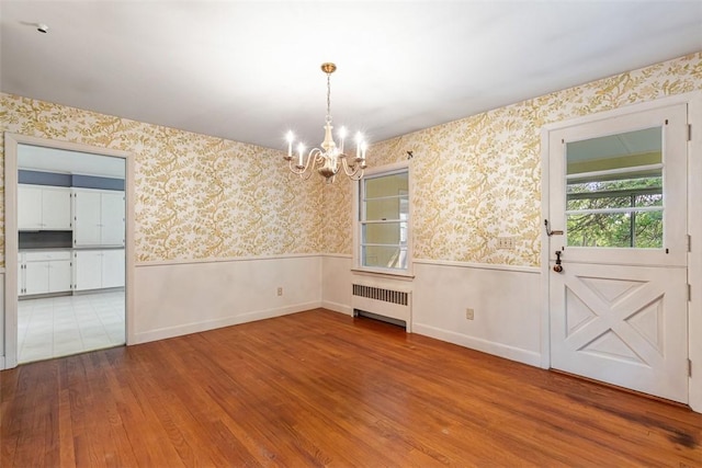 37 Beaumont St, East Providence, RI 02916 - unfurnished dining area featuring radiator heating unit, a wainscoted wall, a chandelier, wood finished floors, and healthy amount of natural light