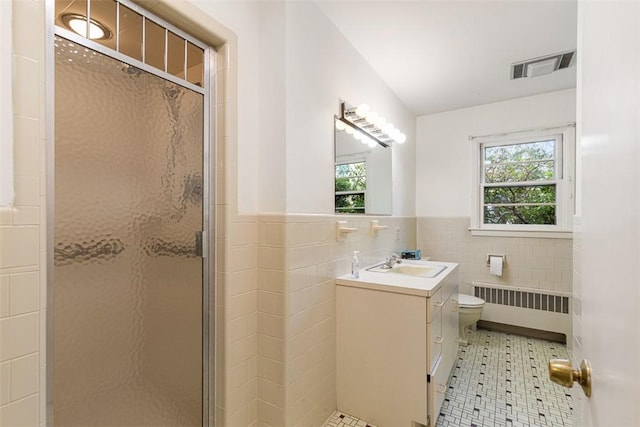 37 Beaumont St, East Providence, RI 02916 - full bathroom featuring radiator heating unit, tile walls, vanity, a shower stall, and tile patterned floors