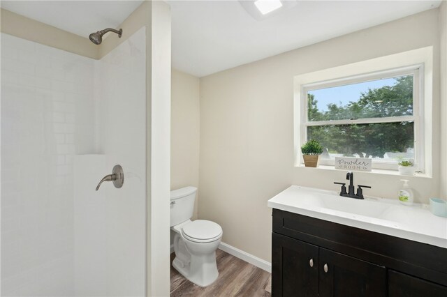 73 Vineyard Ave, Cumberland, RI 02864 - bathroom with wood finished floors, toilet, a tile shower, vanity, and baseboards