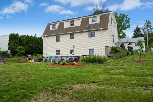 73 Vineyard Ave, Cumberland, RI 02864 - back of house featuring roof with shingles, a gambrel roof, a yard, and a patio area