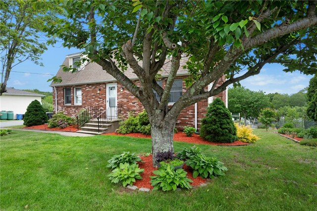 73 Vineyard Ave, Cumberland, RI 02864 - view of front facade featuring brick siding and a front yard