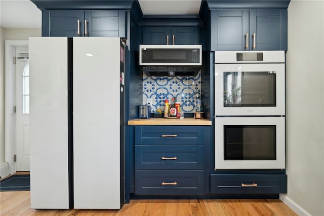 73 Vineyard Ave, Cumberland, RI 02864 - kitchen with white appliances, blue cabinets, light wood-style floors, baseboards, and light countertops