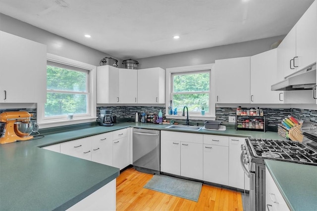 15 Boyd Ave, East Providence, RI 02914 - kitchen with appliances with stainless steel finishes, a sink, under cabinet range hood, light wood-style floors, and decorative backsplash