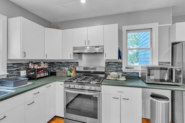 15 Boyd Ave, East Providence, RI 02914 - kitchen featuring appliances with stainless steel finishes, under cabinet range hood, white cabinets, decorative backsplash, and dark countertops