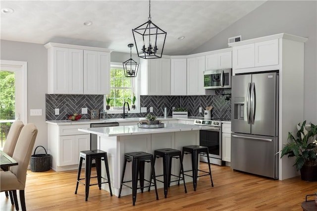 128 Old Quarry Rd, Glocester, RI 02857 - kitchen with appliances with stainless steel finishes, light countertops, healthy amount of natural light, a breakfast bar, and vaulted ceiling