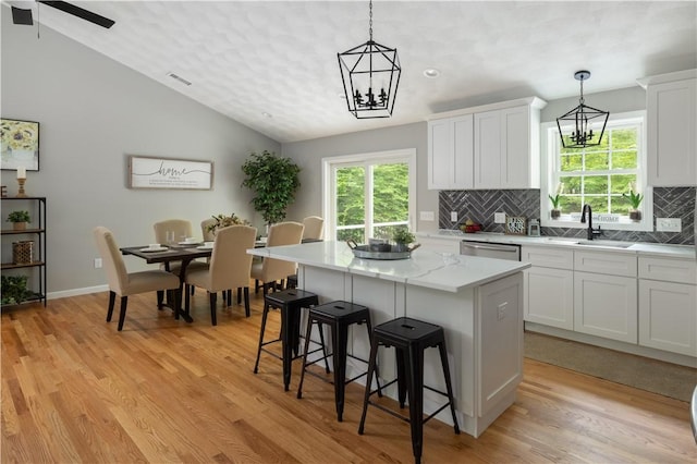 128 Old Quarry Rd, Glocester, RI 02857 - kitchen featuring stainless steel dishwasher, a sink, a kitchen island, tasteful backsplash, and light wood-type flooring