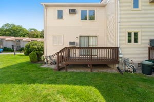 500 E Greenwich Ave Unit 108, West Warwick, RI 02893 - rear view of property with a wooden deck and a lawn
