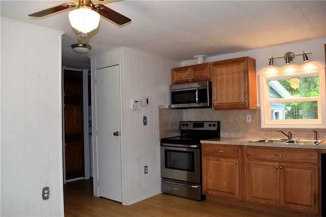 19 Jacob Perry Dr, Charlestown, RI 02831 - kitchen with stainless steel appliances, a sink, light wood-style floors, and brown cabinetry