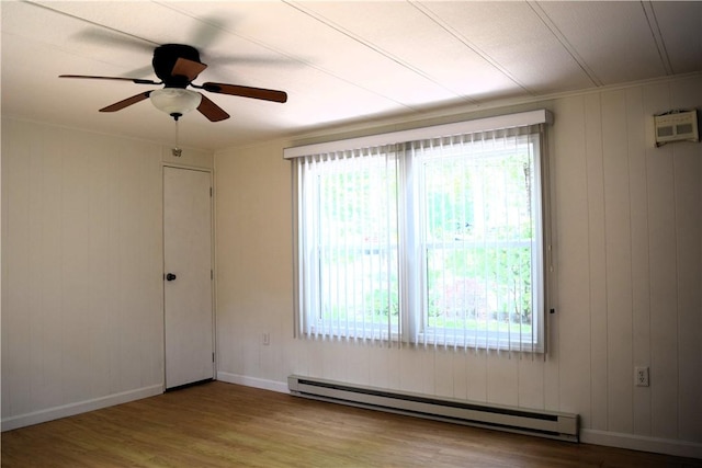 19 Jacob Perry Dr, Charlestown, RI 02831 - empty room with baseboard heating, wood finished floors, ceiling fan, baseboards, and wooden walls