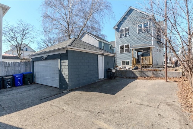 214 Silver Spring St, Providence, RI 02904 - rear view of house with concrete block siding, an outdoor structure, and roof with shingles
