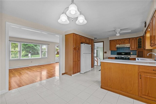 174 Russell Dr, Tiverton, RI 02878 - kitchen with white appliances, a baseboard radiator, under cabinet range hood, light countertops, and brown cabinetry