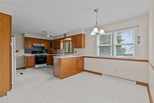174 Russell Dr, Tiverton, RI 02878 - kitchen featuring gas range, under cabinet range hood, a baseboard heating unit, a peninsula, and light countertops