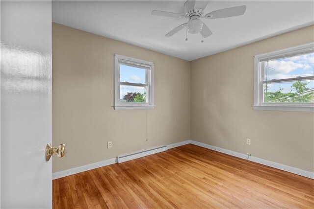 174 Russell Dr, Tiverton, RI 02878 - empty room featuring a baseboard heating unit, plenty of natural light, light wood-type flooring, and ceiling fan
