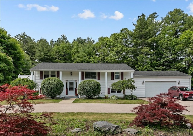 386 Mishnock Rd, West Greenwich, RI 02817 - bi-level home featuring concrete driveway, a garage, and a front lawn