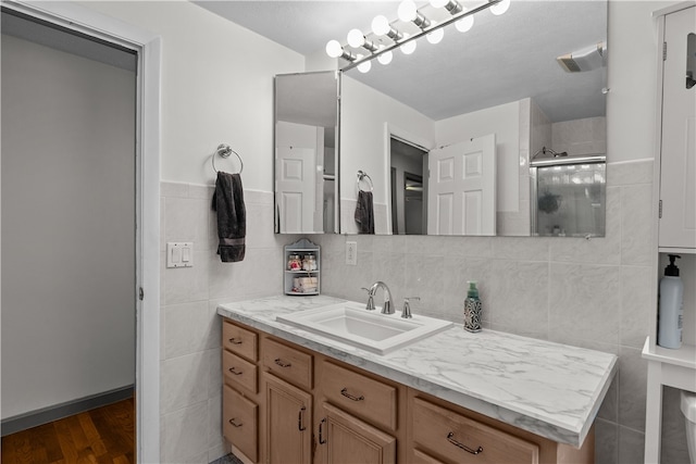 386 Mishnock Rd, West Greenwich, RI 02817 - bathroom with vanity, tile walls, a tile shower, wood finished floors, and wainscoting