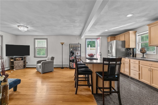 386 Mishnock Rd, West Greenwich, RI 02817 - kitchen with light brown cabinets, baseboard heating, stainless steel fridge, a breakfast bar, and recessed lighting