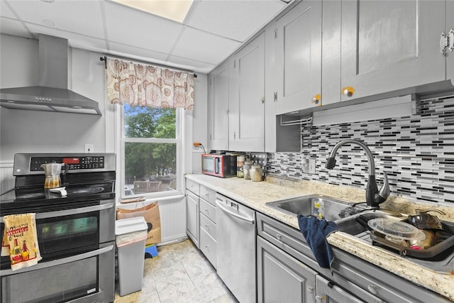 20 Cold Spring Pl, Woonsocket, RI 02895 - kitchen with wall chimney exhaust hood, appliances with stainless steel finishes, decorative backsplash, gray cabinetry, and a drop ceiling