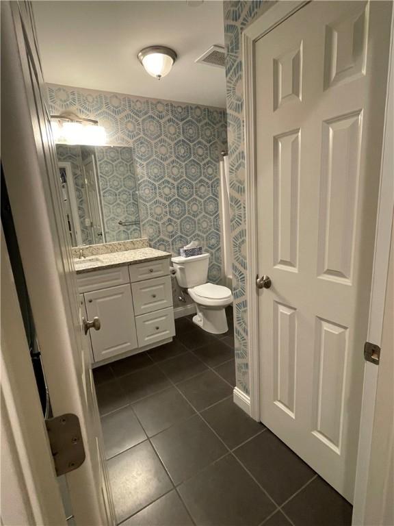 60 Saw Mill Dr Unit 303, North Kingstown, RI 02852 - bathroom with wallpapered walls, tile patterned floors, vanity, and toilet