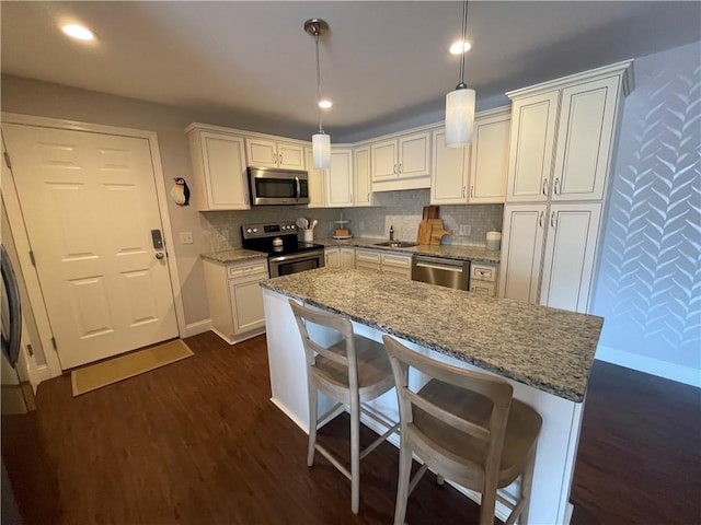 60 Saw Mill Dr Unit 303, North Kingstown, RI 02852 - kitchen featuring stainless steel appliances, baseboards, dark wood-type flooring, light stone countertops, and recessed lighting