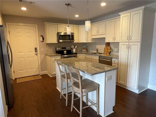 60 Saw Mill Dr Unit 303, North Kingstown, RI 02852 - kitchen featuring stainless steel appliances, a sink, baseboards, dark wood finished floors, and backsplash