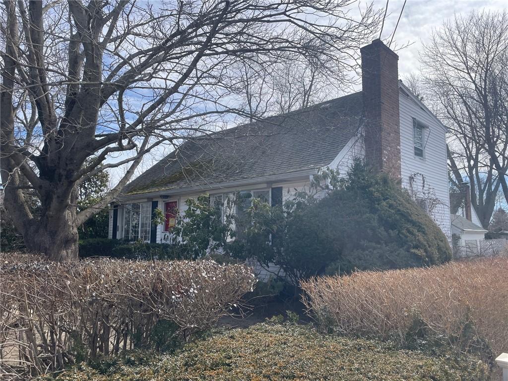 137 Bayview Ave, North Kingstown, RI 02852 - view of home's exterior featuring a chimney and a shingled roof