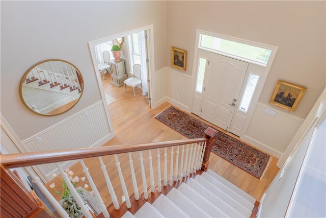 62 James Ct, Portsmouth, RI 02871 - entrance foyer featuring a wainscoted wall, a decorative wall, stairs, wood finished floors, and plenty of natural light